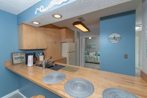 A kitchen with wooden cabinets, a sink, and a countertop with decorative plates.