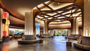 A spacious lobby with curved seating areas, a modern ceiling design, and a reception desk.
