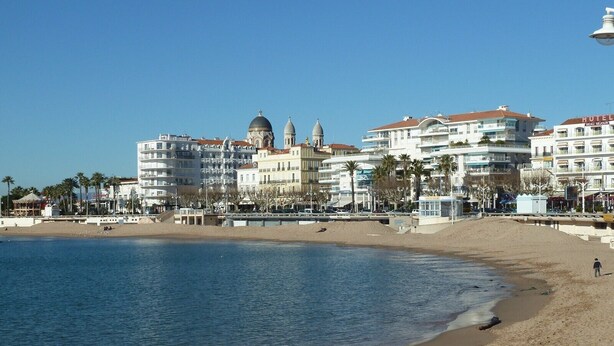 A beachside hotel with multiple floors, a prominent dome structure, and a beach in the foreground. - Renovated apartment in Valescure, with pool and golf view, near the sea  (Saint-Raphaël)