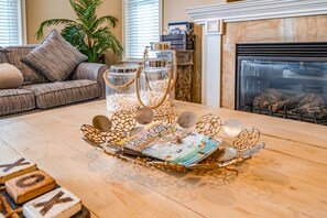 Een houten bijzettafeltje met decoratieve glazen potten, een tijdschrift en een dienblad met brieven.