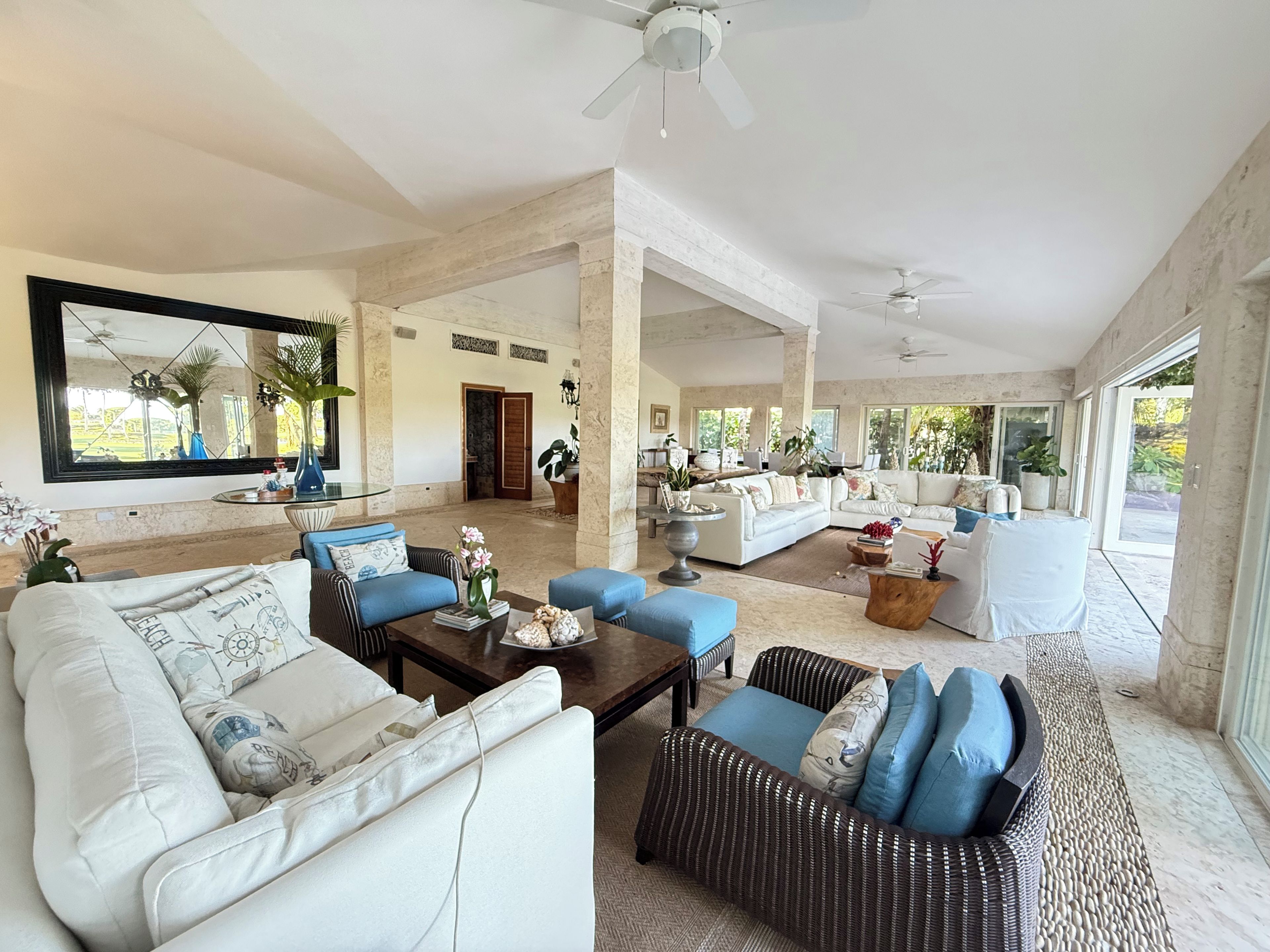 A spacious living area with a large mirror, sofas, and a coffee table.