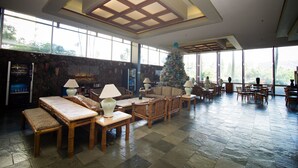 A spacious lobby with a stone wall, large windows, and a Christmas tree. - Enjoy the Gorgeous Mountain, Canal and Golf Course Views #2120 (Honolulu)