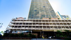 A multi-story hotel with a modern design, featuring a prominent entrance with a covered area and a parking lot visible in front. - Enjoy the Gorgeous Mountain, Canal and Golf Course Views #2120 (Honolulu)