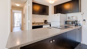 A modern kitchen with dark cabinets, a granite countertop, a built-in microwave, and a dishwasher. - Enjoy the Gorgeous Mountain, Canal and Golf Course Views #2120 (Honolulu)