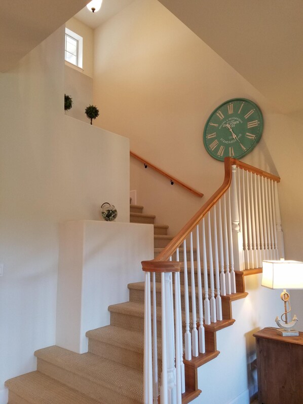 A staircase with wooden railings and beige carpeted steps.