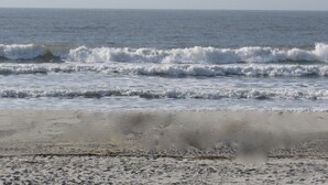 A beach with waves approaching the shore.