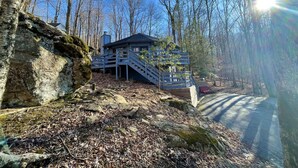 A cabin with a staircase leading to a deck, surrounded by a forest. - Unique Round House on Beech Mtn -Ski, Hike, Golf, Fish-Near Wineries & Parkway (Beech Mountain)