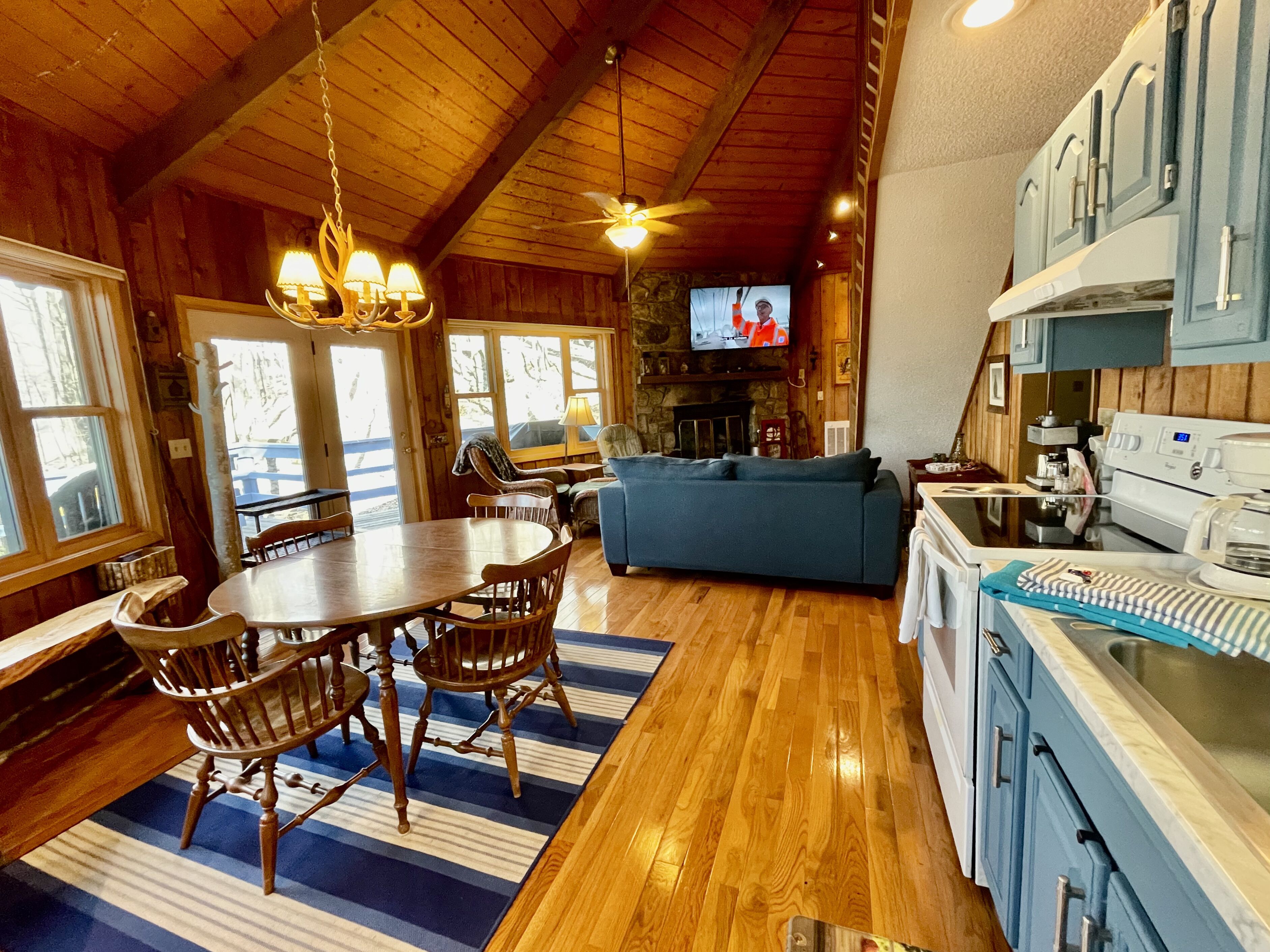 A cozy cabin interior with a dining area, living room, and kitchen.