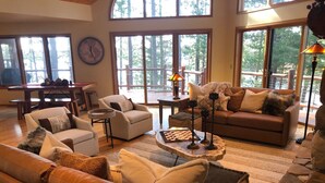 A spacious living room with a large window, a fireplace, and a cozy seating area.