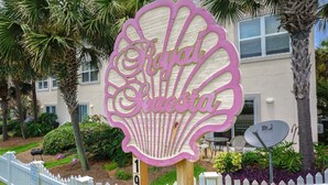 A decorative sign with the text "Royal Palm" in a stylized font, mounted on a wooden post. - Spacious 3bd 3ba, 1 min walk to private beach with 2 master king bed (Miramar Beach)