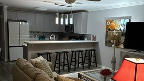 A modern living room with a beige sofa, a glass coffee table, and a red lamp. - Spacious 3bd 3ba, 1 min walk to private beach with 2 master king bed (Miramar Beach)