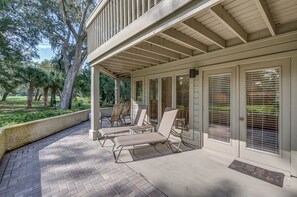 Relax in a serene outdoor space with comfortable seating and tables, surrounded by lush greenery and a tranquil atmosphere.