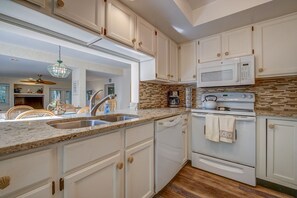 Enjoy cooking in this well-equipped kitchen with a microwave, stainless steel sink, and stove.