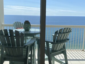 Enjoy the ocean view from this balcony with Adirondack chairs and a table.