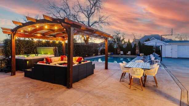 Une terrasse extérieure avec un jacuzzi, des sièges et une table de billard.