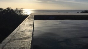 Una plataforma de hormigón con vistas al océano al atardecer.