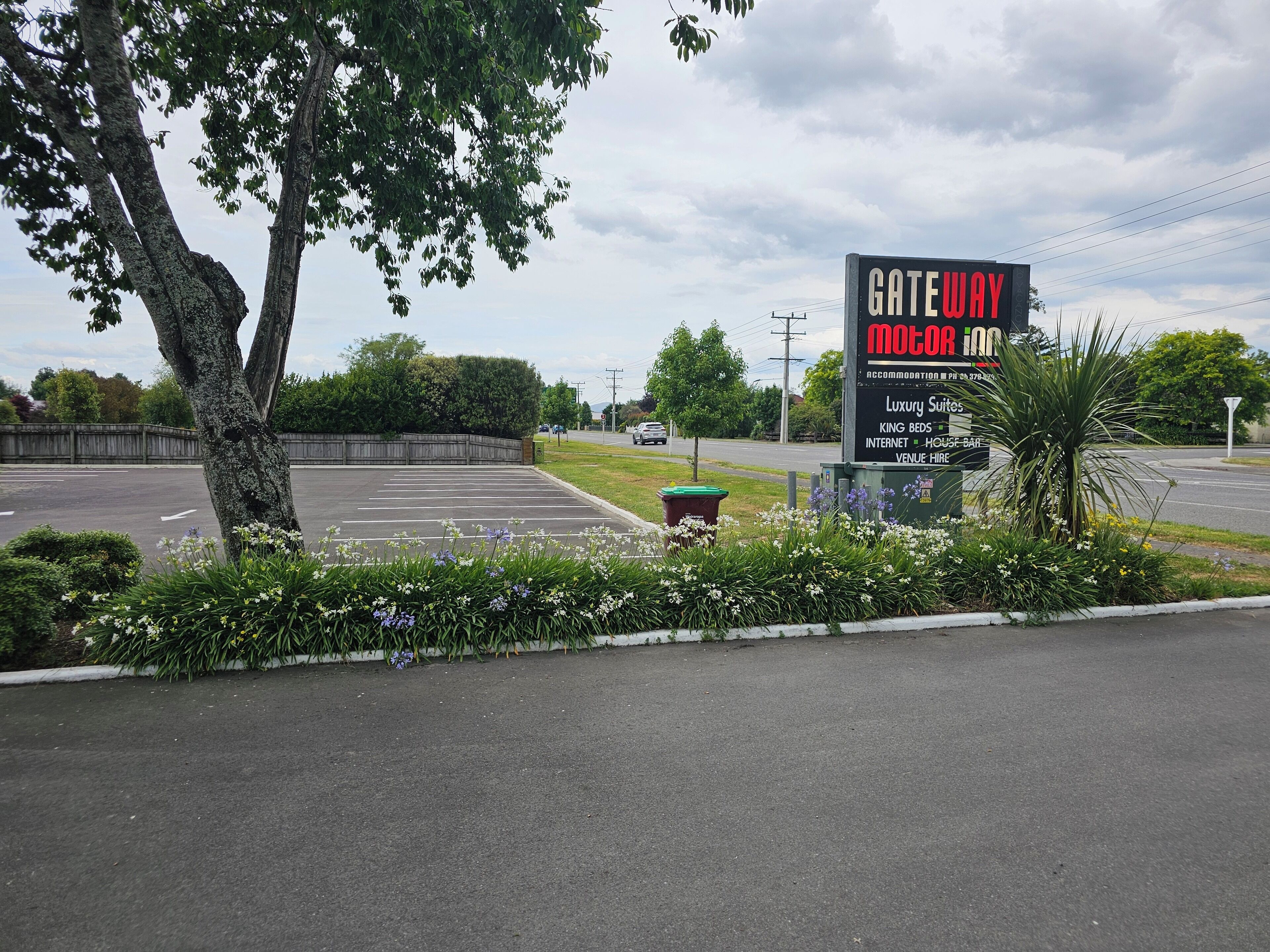 A sign for Gateway Motor Inn advertising luxury suites, king beds, internet, and a house bar.