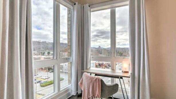 Una habitación con ventanas amplias, un escritorio y una silla.