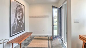 A hallway with a bench, a framed picture on the wall, a door with a glass panel, and a tiled floor. - 243 Short Coxe Ave Townhome (Asheville)