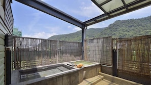 A hot spring bath area with a view of a forested hill. - A-SAN Hot Spring Hotel (Jiaoxi)