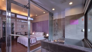 A modern hotel room with a glass partition, a bed, a bathroom with a shower, and a small desk area. - A-SAN Hot Spring Hotel (Jiaoxi)