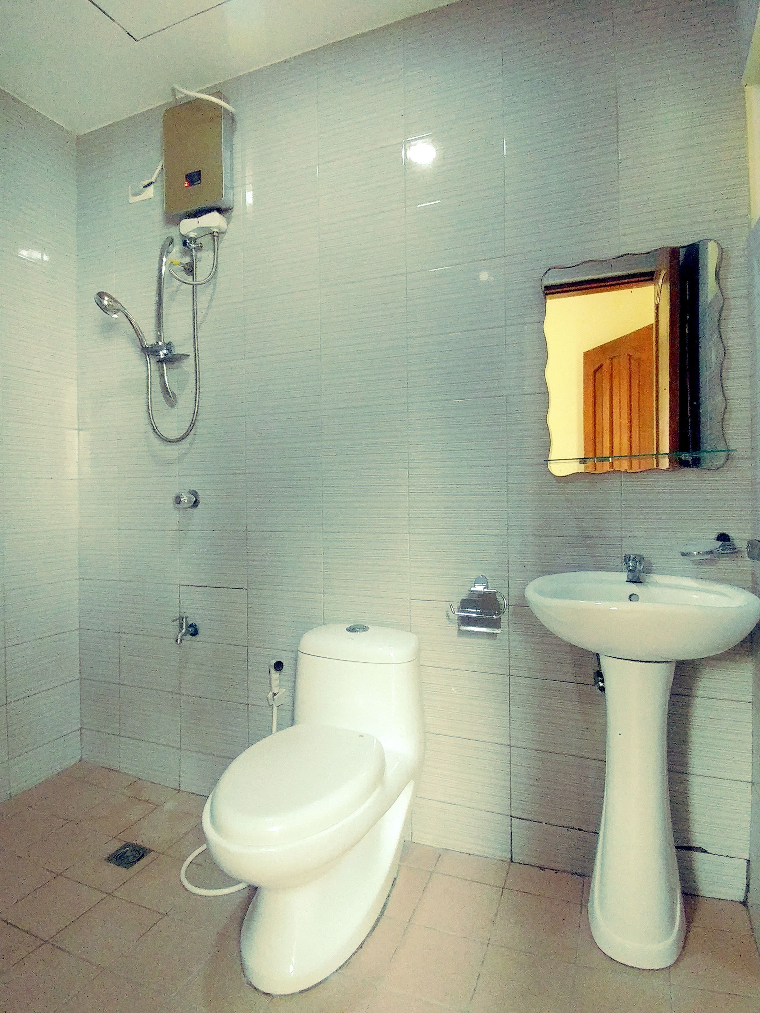A bathroom with a toilet, bidet, and sink.