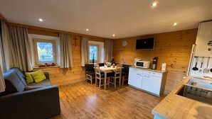 Una habitación acogedora con sofá, mesa de comedor y zona de cocina.