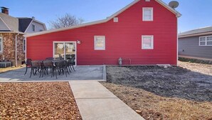 A red building with a covered patio area and outdoor seating. - The Farmhouse Inn: 3 bed, 3.5 whole house rental (Hermann)