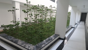 A modern indoor garden with a variety of trees and a tiled floor. - Garco Dragon Hotel 2 (Hanoi)
