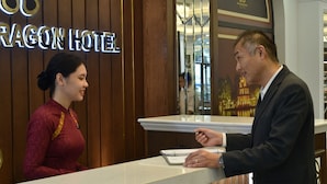 A hotel reception desk with a sign reading "Dragon Hotel". - Garco Dragon Hotel 2 (Hanoi)