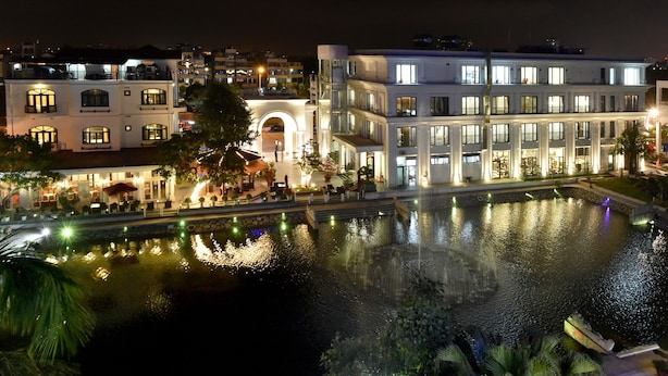 A modern hotel with a pool, illuminated windows, and a well-lit entrance. - Garco Dragon Hotel 2 (Hanoi)