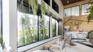 Um café moderno com amplas janelas, área de estar e balcão.