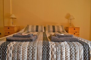 Un lit double avec une literie à motifs et deux tables de chevet avec des lampes.