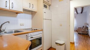 A compact kitchen with white cabinets, a microwave, a refrigerator, an oven, and a sink. - The apartment in Opera Royal Palace! (Madrid)