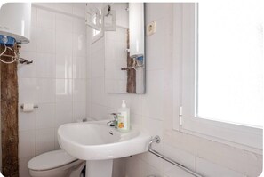 A bathroom with a white sink, toilet, and mirror. - The apartment in Opera Royal Palace! (Madrid)