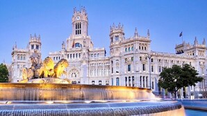 A grand building with a large fountain featuring lion statues. - The apartment in Opera Royal Palace! (Madrid)
