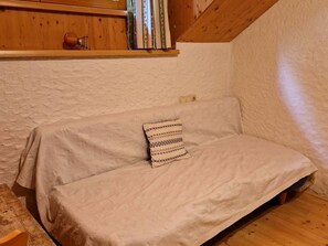 A cozy room with a wooden ceiling, a white textured wall, and a bed with a patterned pillow. - Family room - Pferde- und Schafhof Klinser (Vordertambergau)