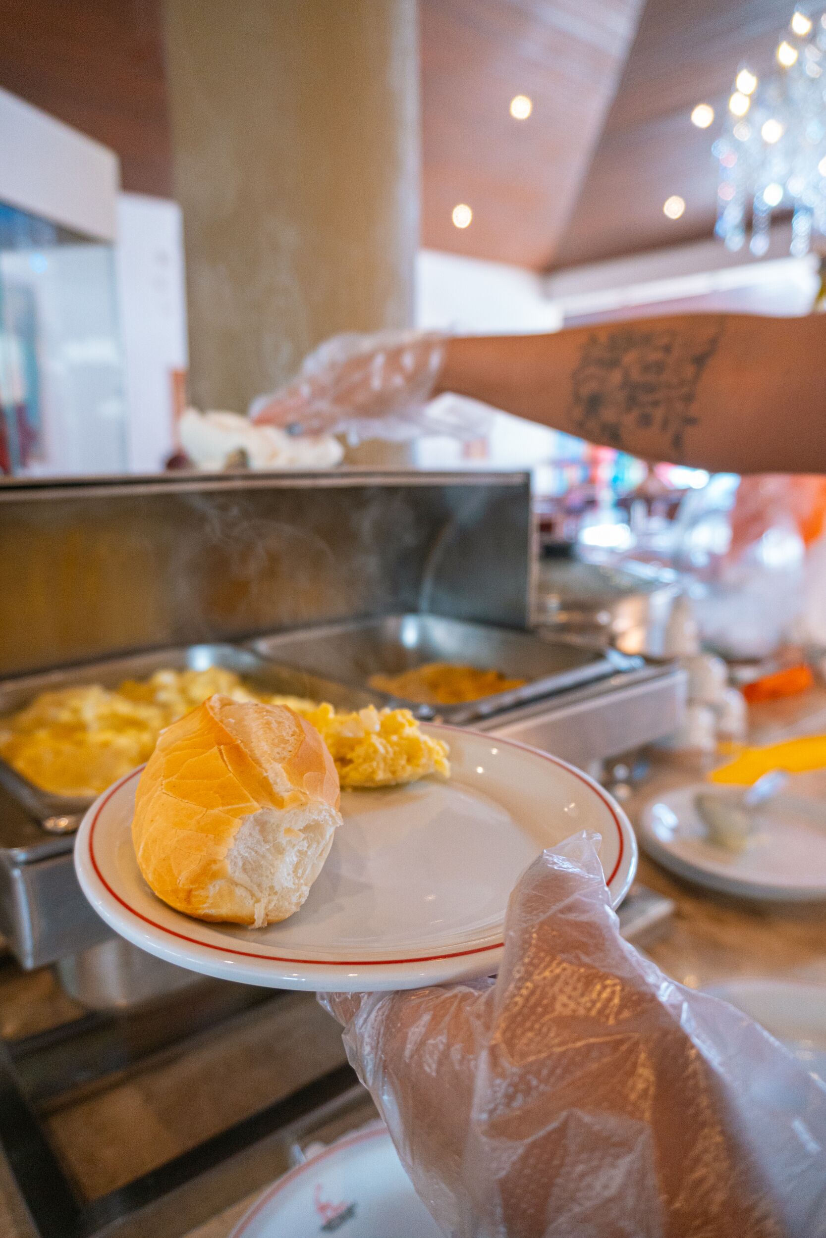 Un buffet proposant divers plats, notamment une assiette avec un petit pain et des œufs brouillés.