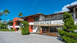 A building with a sign reading "PORTO DAS NAUS" and a star symbol above it. - Porto das Naus Praia Hotel (Porto Seguro)