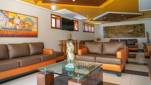 A modern living room with two sofas, a glass coffee table, and artwork on the walls. - Porto das Naus Praia Hotel (Porto Seguro)