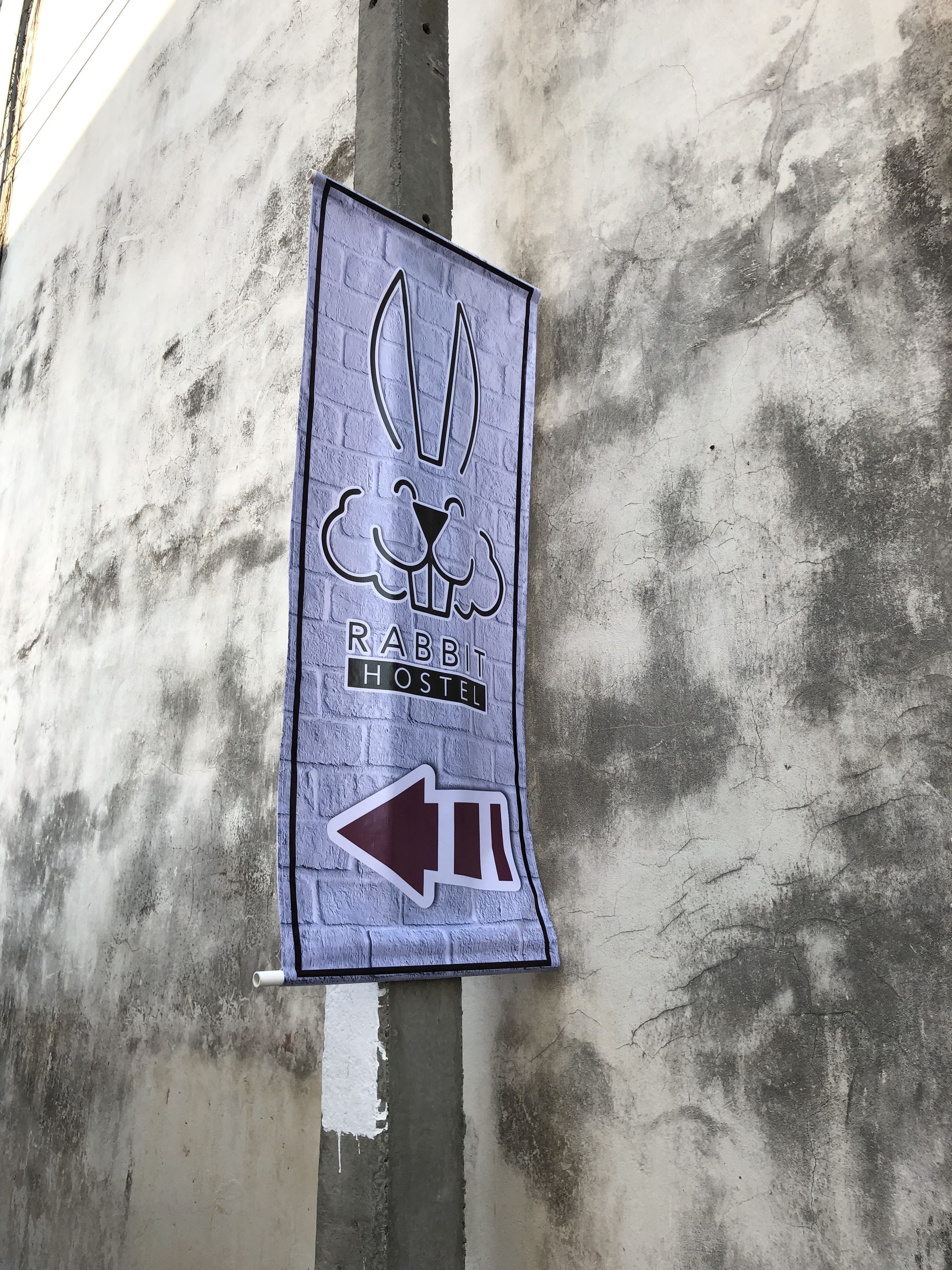 A sign for a Rabbit Hostel with a directional arrow.