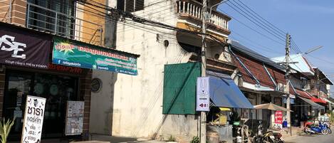 A street view with buildings, a signboard, and a parked car.