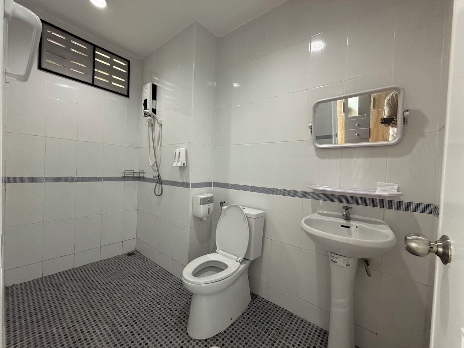 A bathroom with a toilet, sink, and shower.