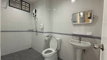 A bathroom with a toilet, sink, and shower.