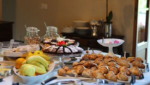 Un bufé con diversos alimentos, incluyendo frutas, pasteles y postres.