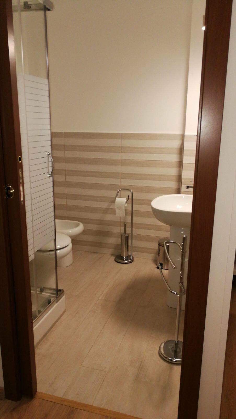 Une salle de bain équipée de toilettes, d’un lavabo et d’une douche à parois de verre.