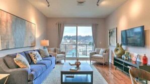 A spacious living room with a sofa set, a coffee table, and a view of a balcony.