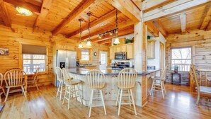 A wooden cabin interior with a kitchen, dining area, and bar. - Deck & Mtn Views! Luxe Log Cabin in Waynesville (Waynesville)