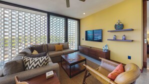 A modern living room with a sectional sofa, a coffee table, and a TV mounted on the wall. - Beautiful Condo in the heart of Zona Romantica! 2BD Condo for rent in Old Town, (Puerto Vallarta)