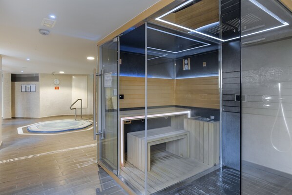 A modern bathroom with a glass enclosure, a wooden bench, and a visible clock on the wall.